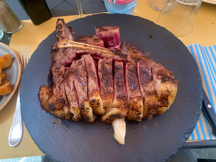 Bistecca alla fiorentina servita su tagliere di ardesia all'Osteria Il Carroccio Siena