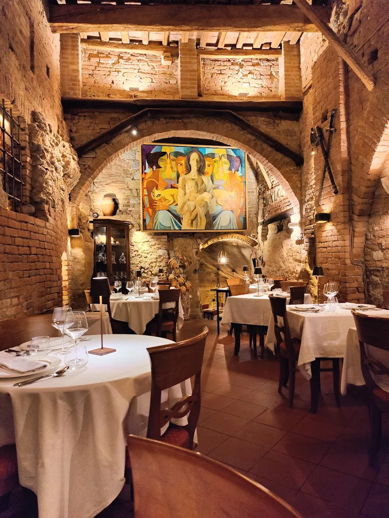 Sala dell'Antica Osteria da Divo Siena con archi in mattoni e grande dipinto contemporaneo