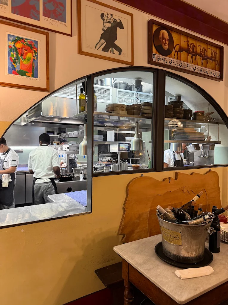 Cucina a vista dell'Osteria Le Logge Siena con quadri alle pareti