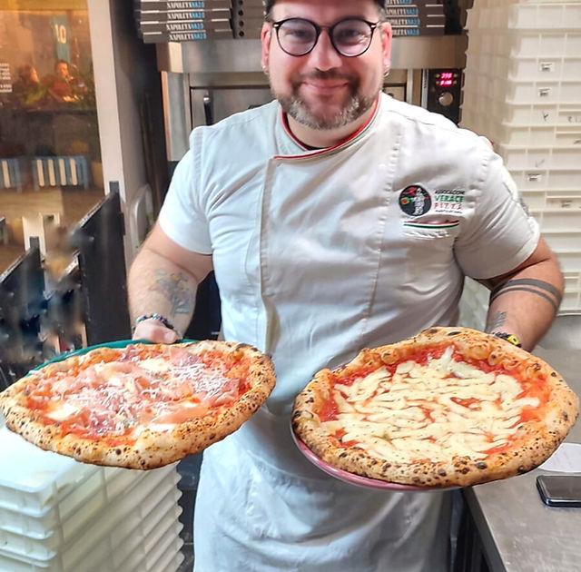 Giancarlo de La Napoletana 2.0 con due pizze appena uscite dal forno