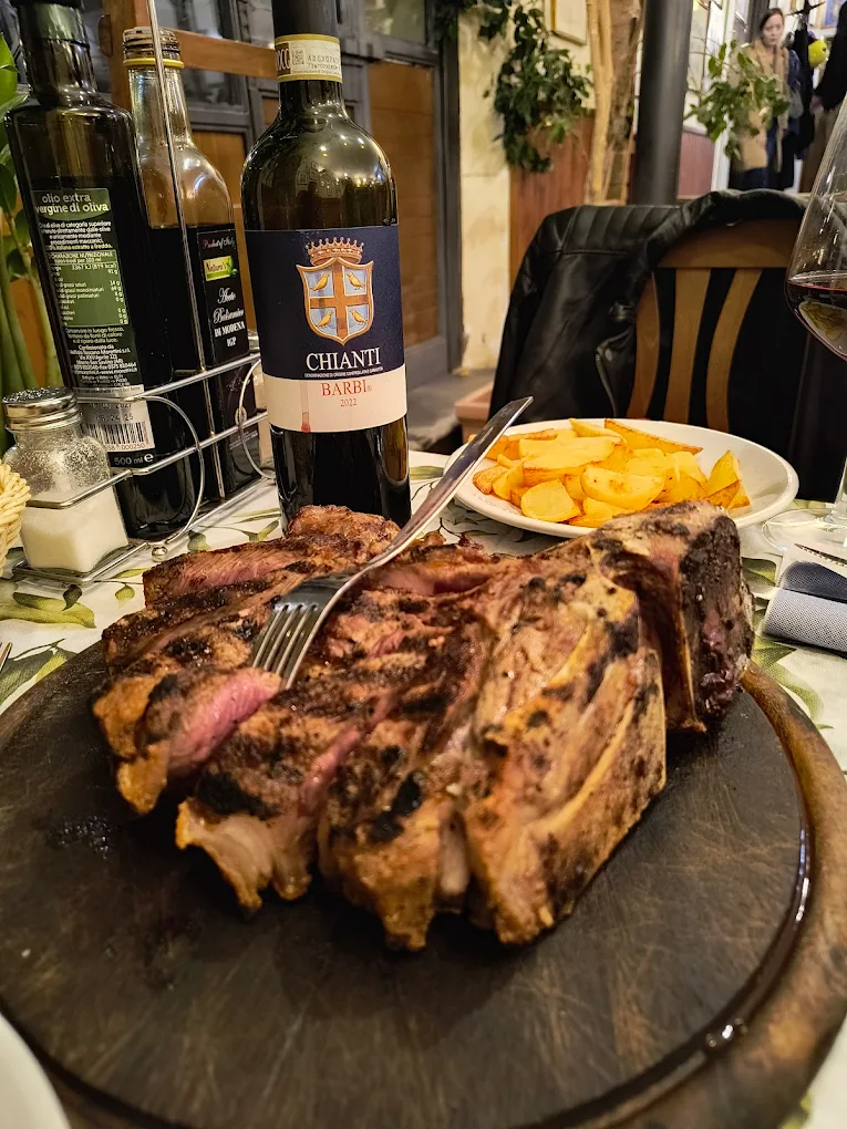 Bistecca alla griglia con patate e bottiglia di Chianti Antica Trattoria Papei Siena