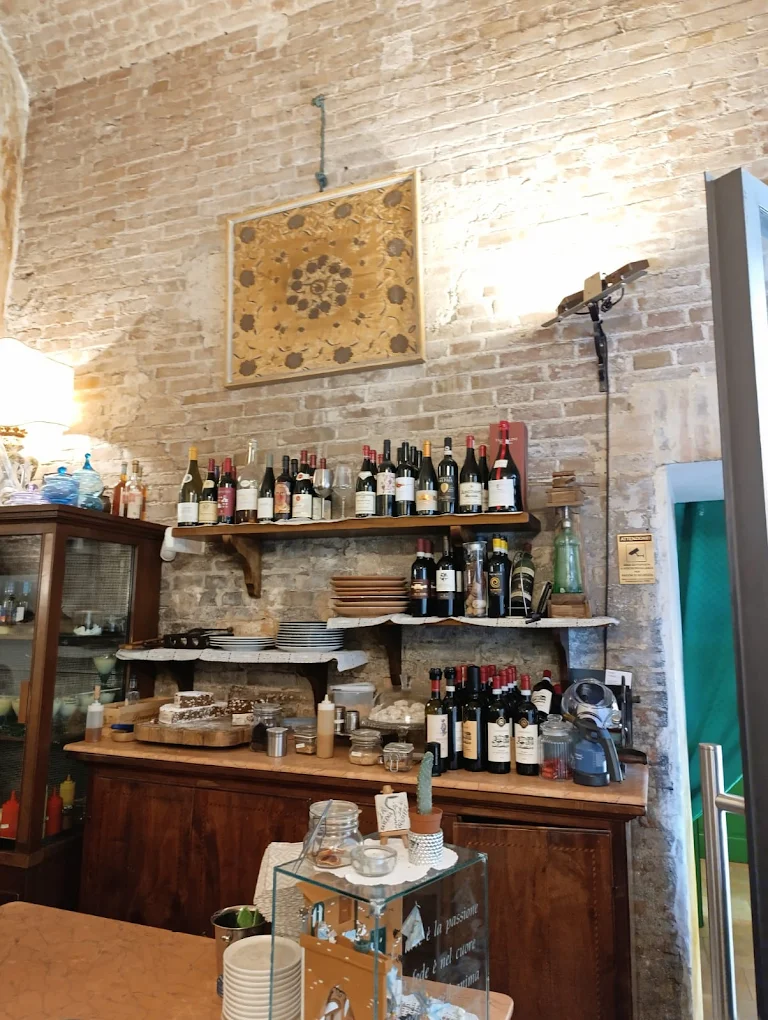 Cantina della Taverna di San Giuseppe Siena con bottiglie su mensole in tufo