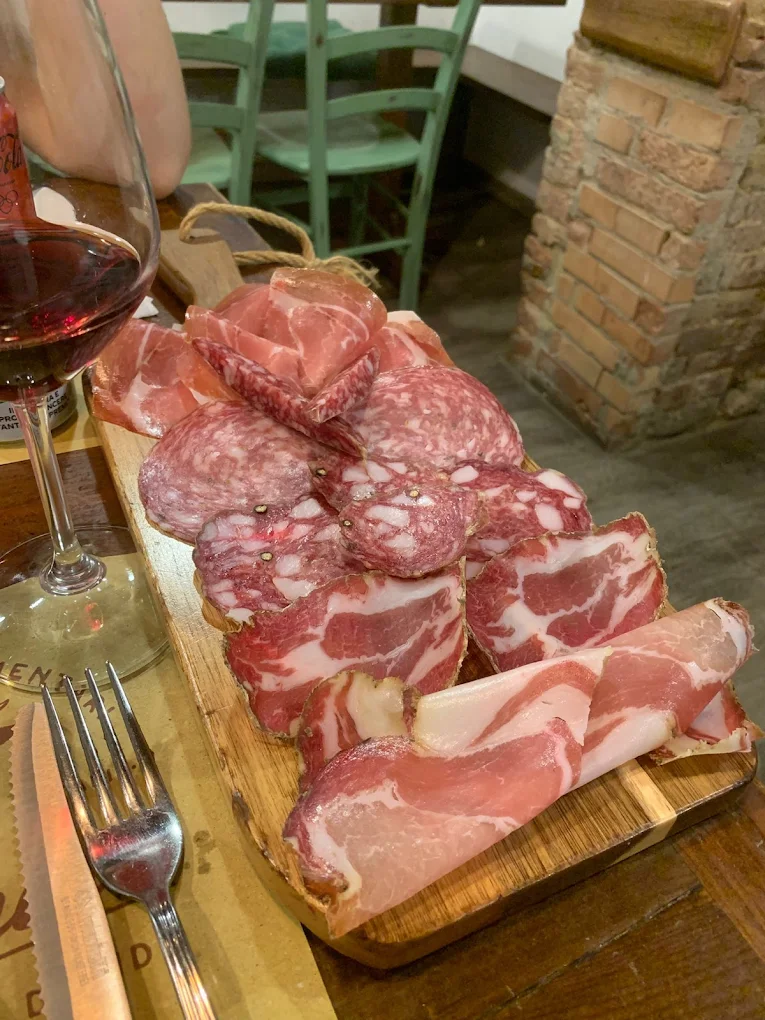 Tagliere toscano di salumi e capocollo con calice di vino rosso all'Osteria Il Vinaio Siena